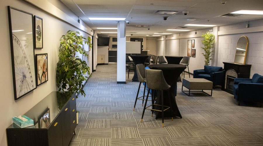 Untitled design (1) Lounge meeting space with tables, chairs, and a couch